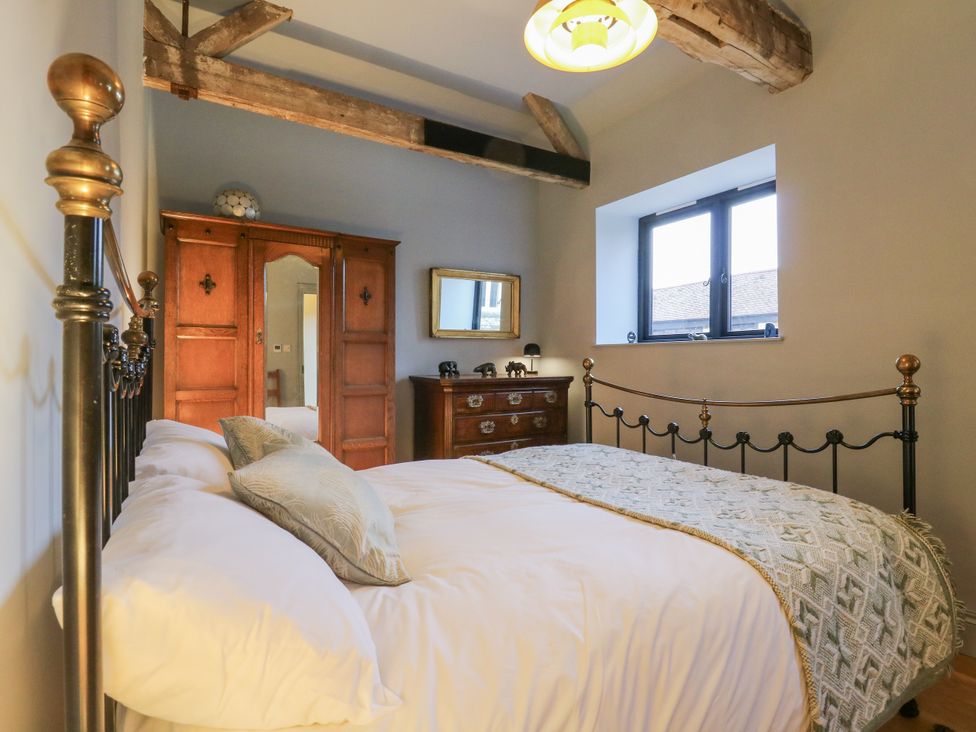 A bedroom with a bed and wardrobe at The Apartment in Oving near Whitchurch, Buckinghamshire