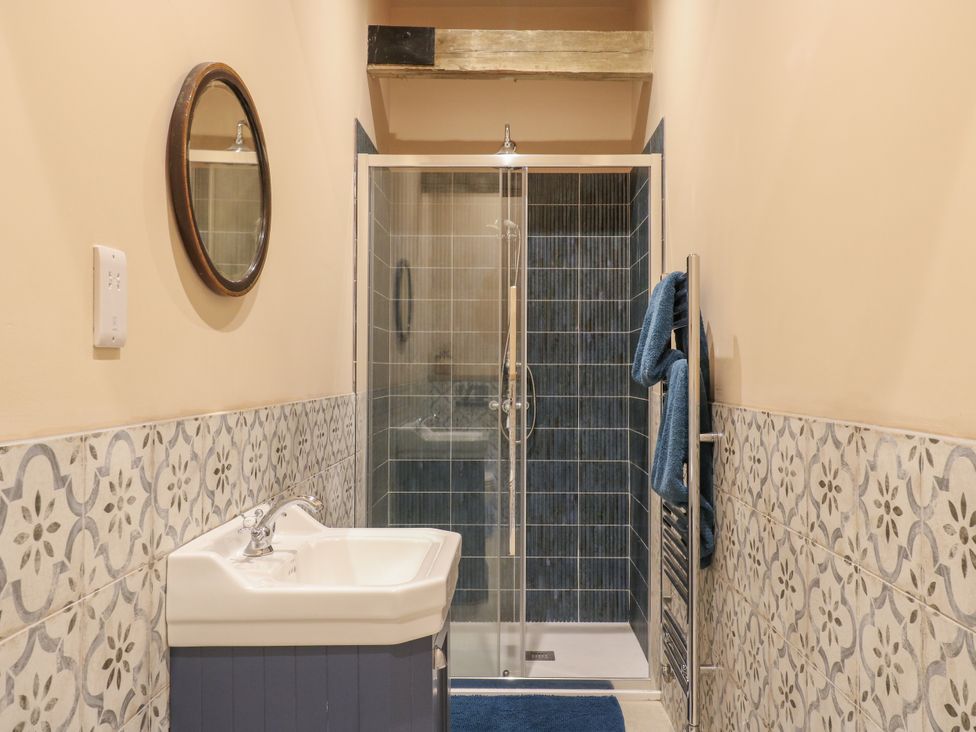 A bathroom with a shower, sink, and towels at The Apartment in Oving near Whitchurch, Buckinghamshire