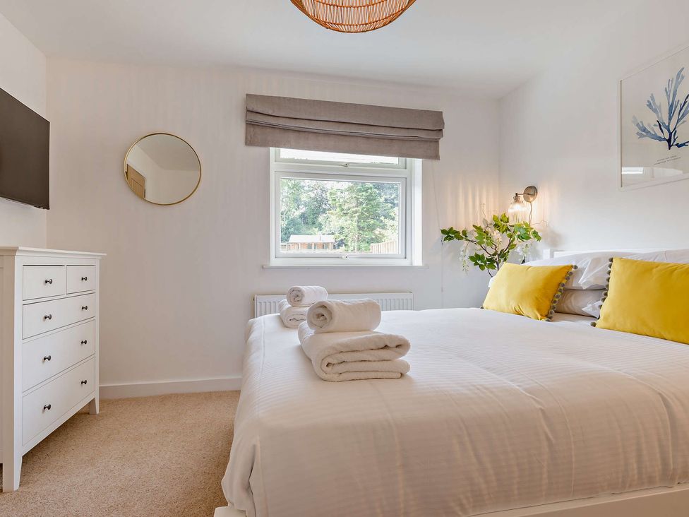 A bedroom with a bed and dresser at Klys 1.0 Spa in Perranporth