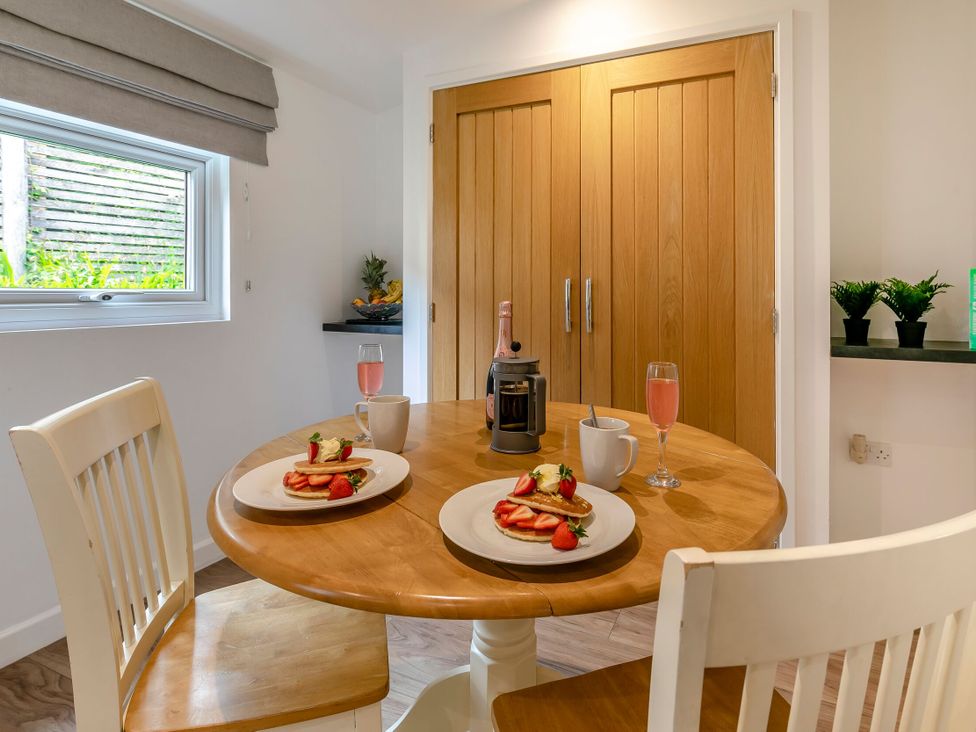A dining room with food and drinks on a table at Chapel Rock Spa Pet in Perranporth