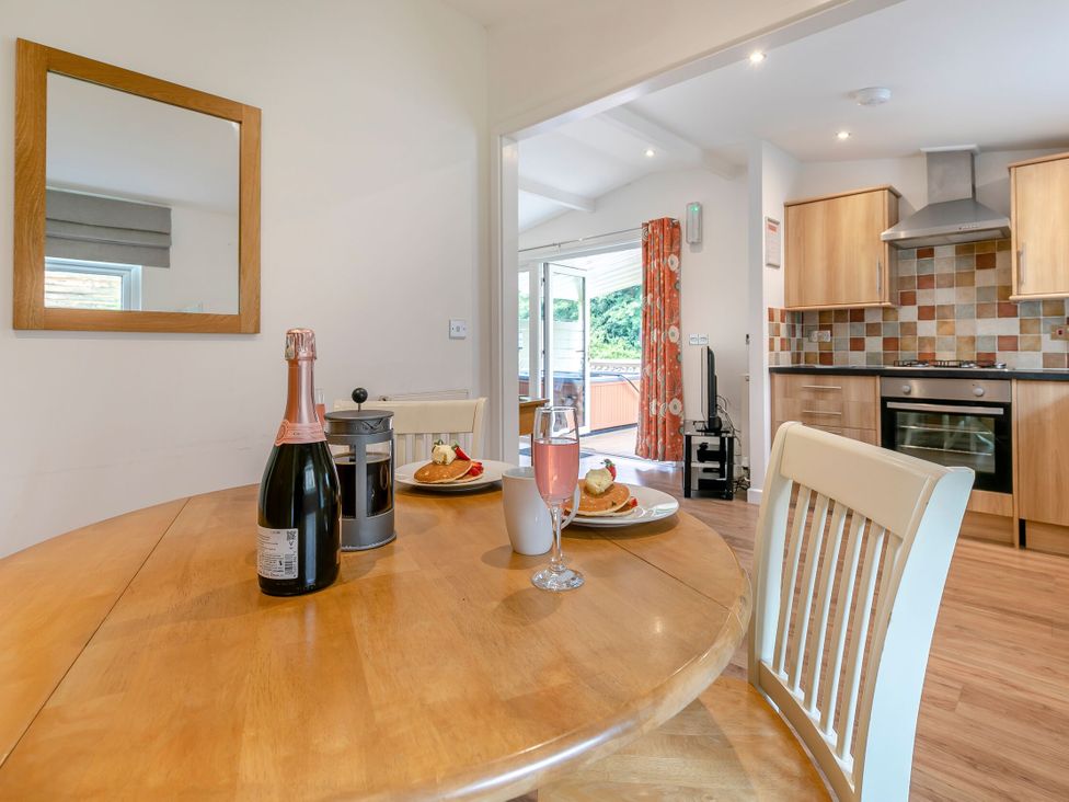 A dining area with a table and chairs at Chapel Rock Spa Pet in Perranporth