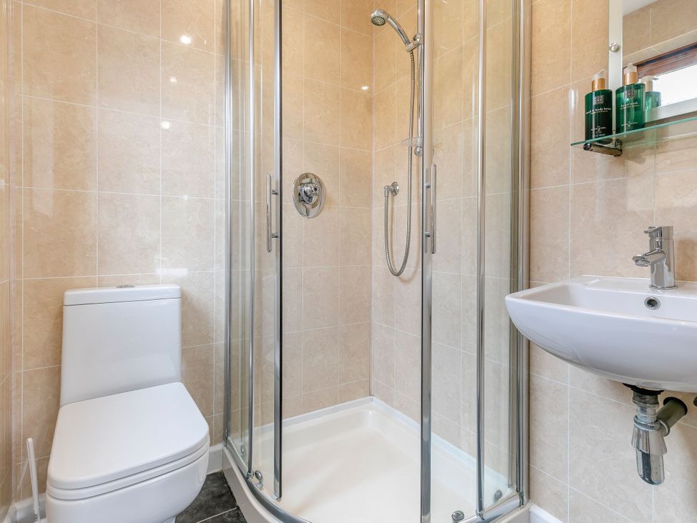 A bathroom with a shower, toilet, and sink at Chapel Rock Spa Pet, Perranporth