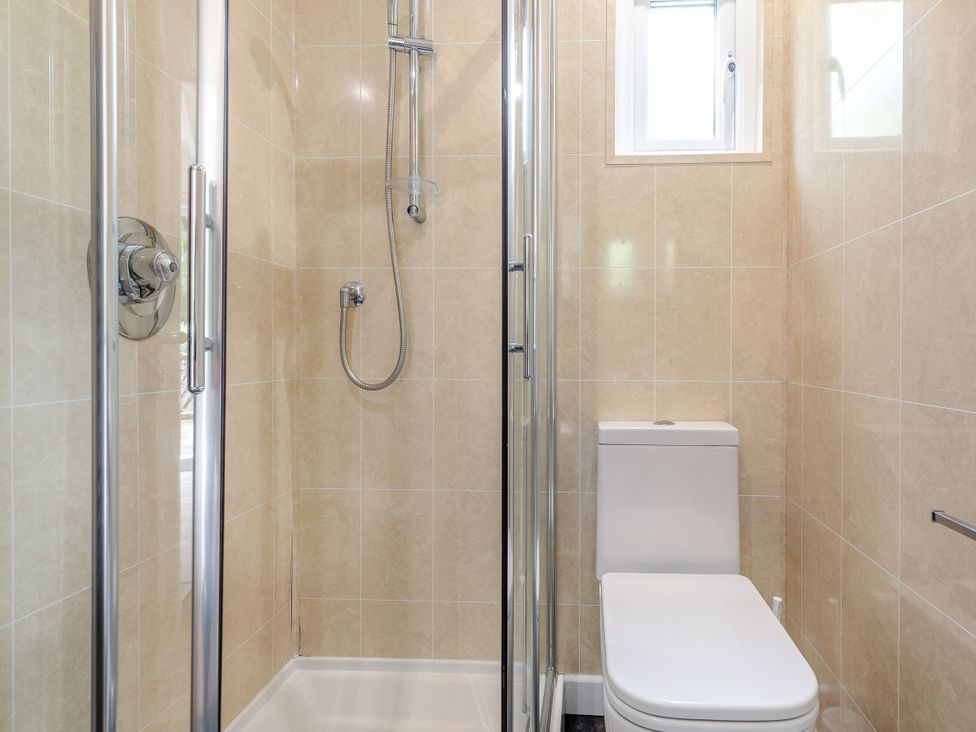 A bathroom with a shower cubicle and a toilet at Droskyn Spa Pet in Perranporth