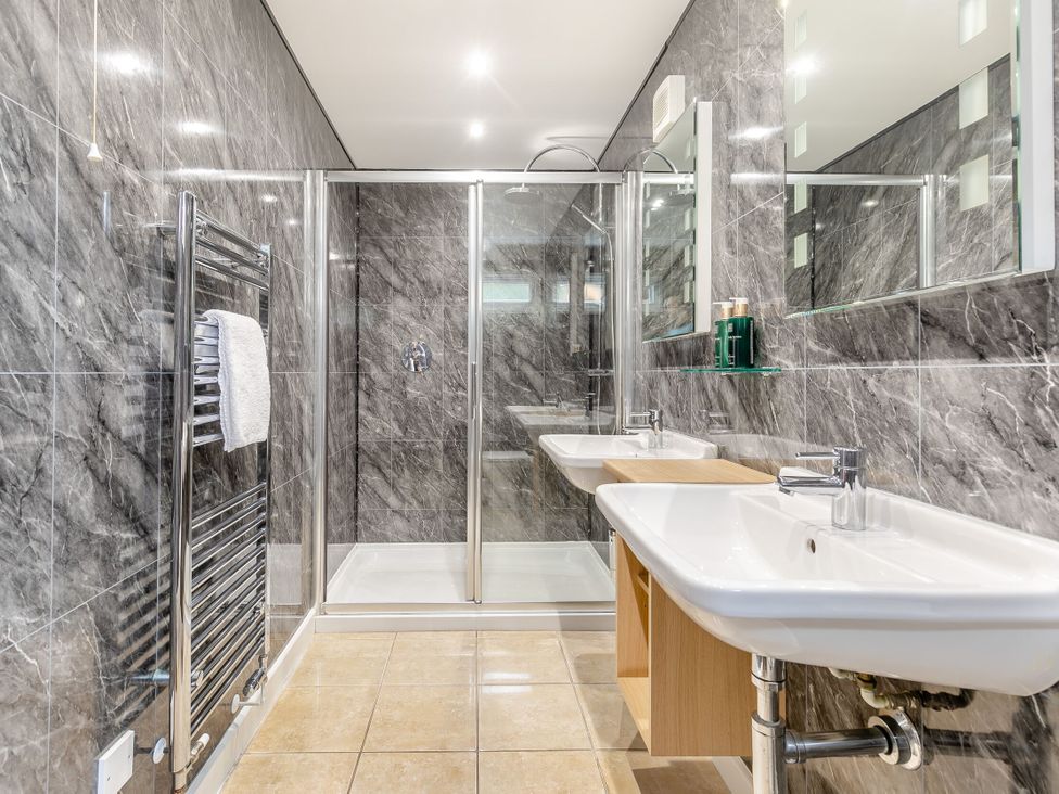A bathroom with sinks and a shower at Tremewan Spa Pet Perranporth