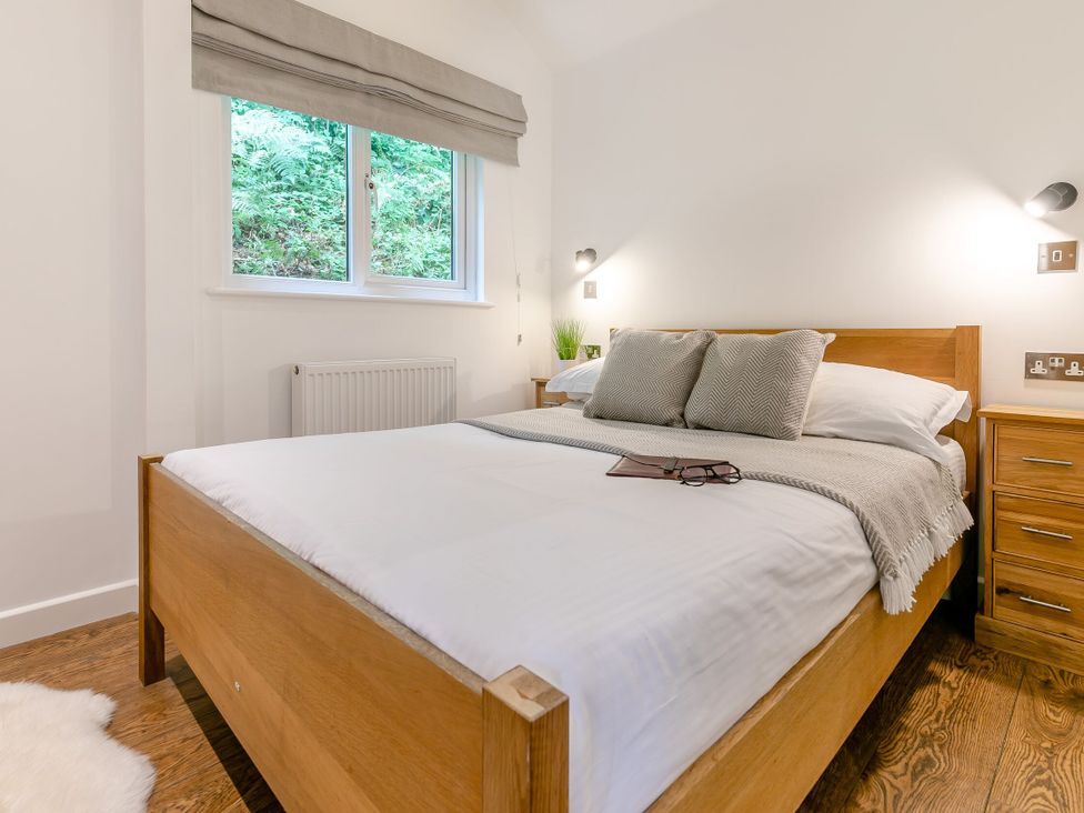 A bedroom with a bed and window at Tremewan Spa Pet Perranporth