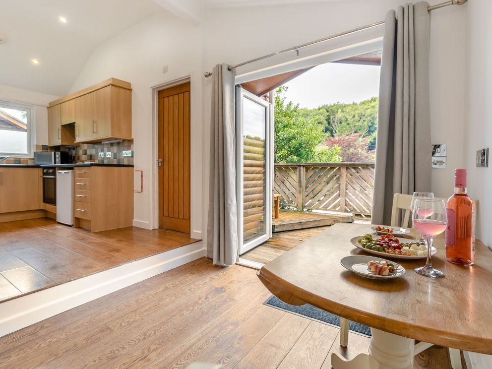 A kitchen with a dining area and an outdoor view at Tremewan Spa Pet Perranporth