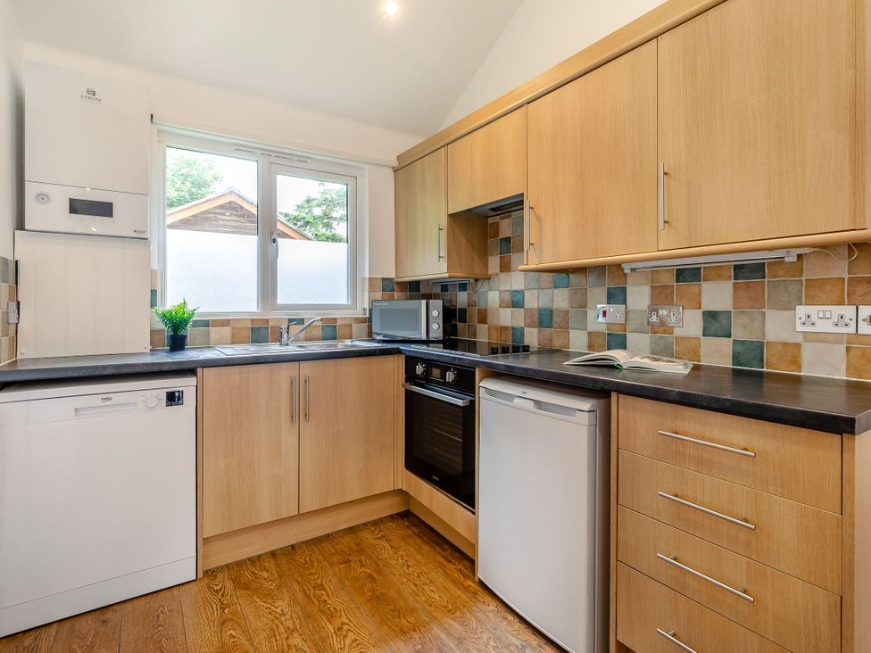 A kitchen with appliances and window at Tremewan Spa Pet Perranporth
