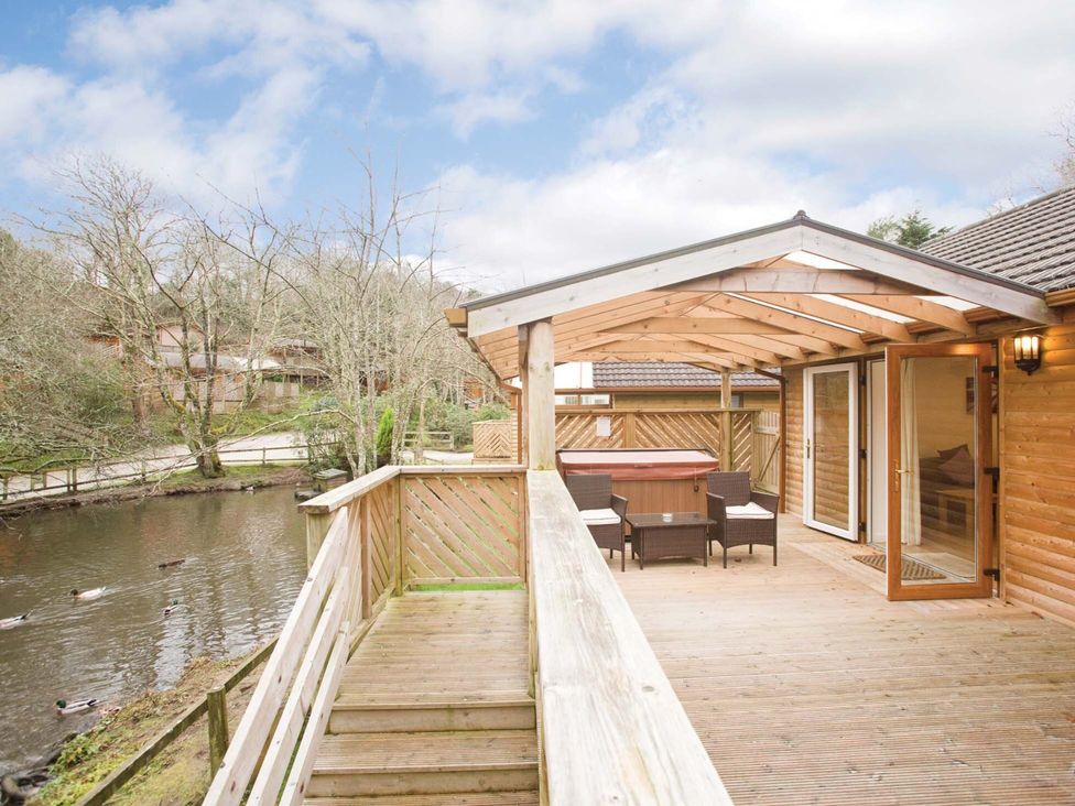 An outdoor area with a hot tub and seating at Poldark Spa Pet in Perranporth