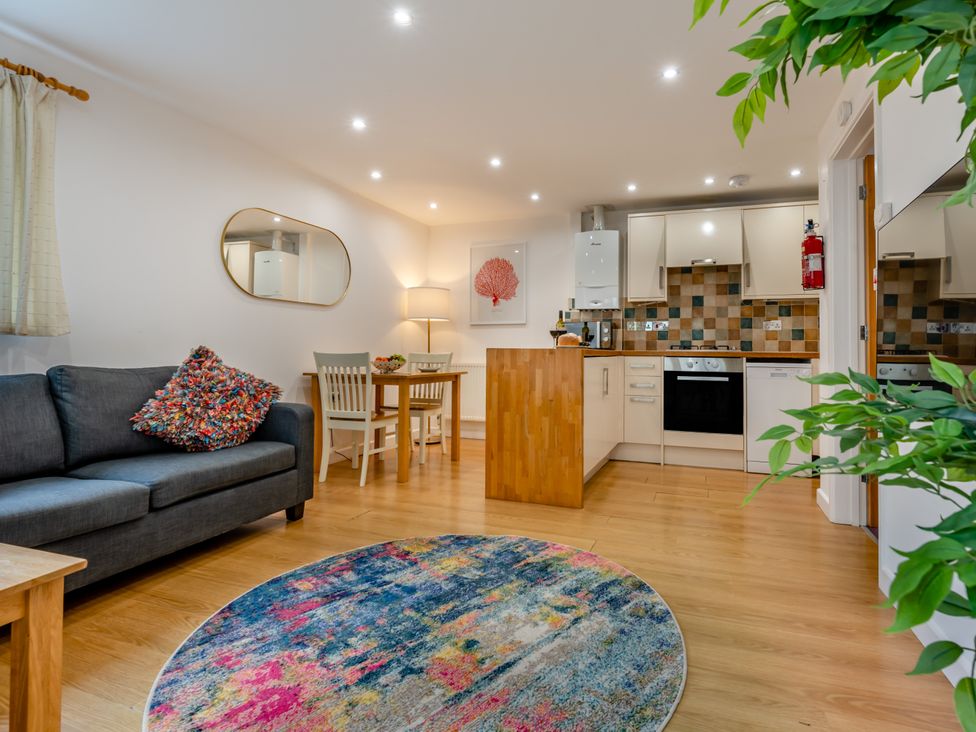 A living room with a sofa and dining area at Poldark Spa Pet Perranporth