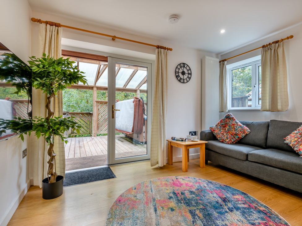 A living room with a sofa and potted plant at Poldark Spa Pet in Perranporth