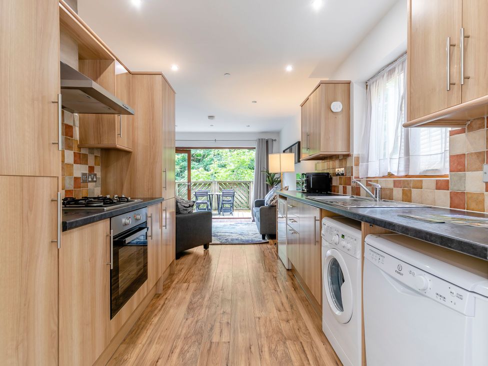 A kitchen with appliances and a dining area at Treehouse Spa in Perranporth