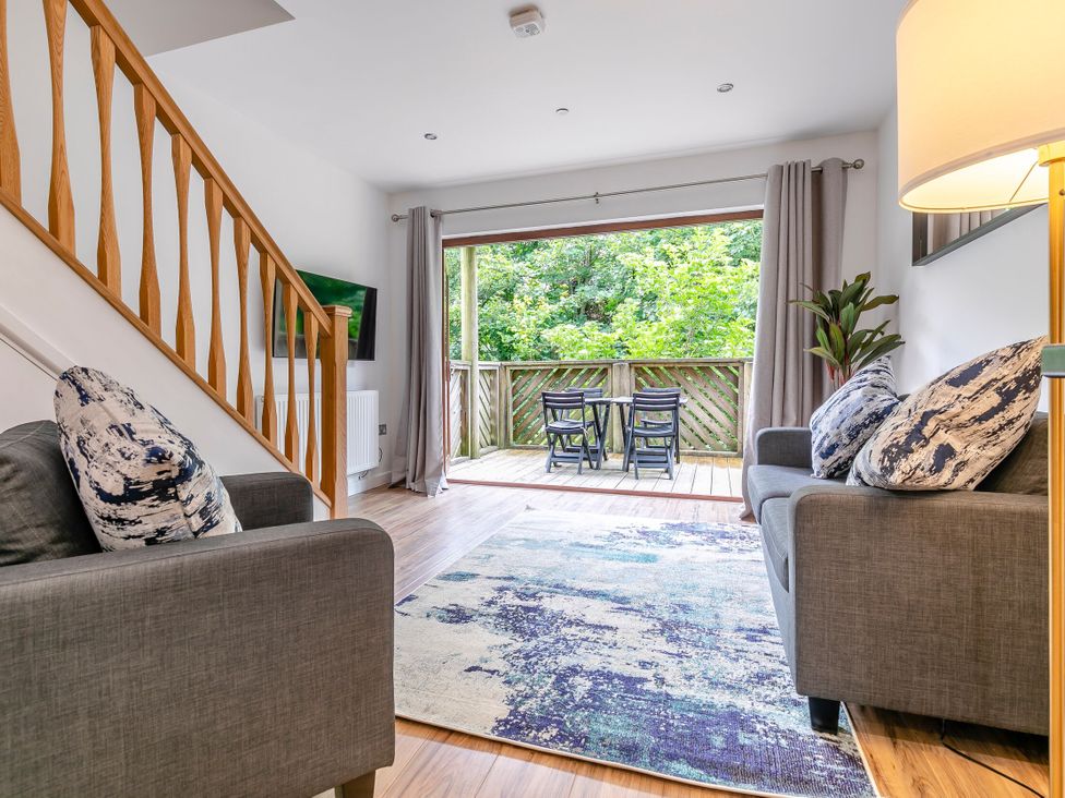A living room with a sofa and television at Treehouse Spa in Perranporth