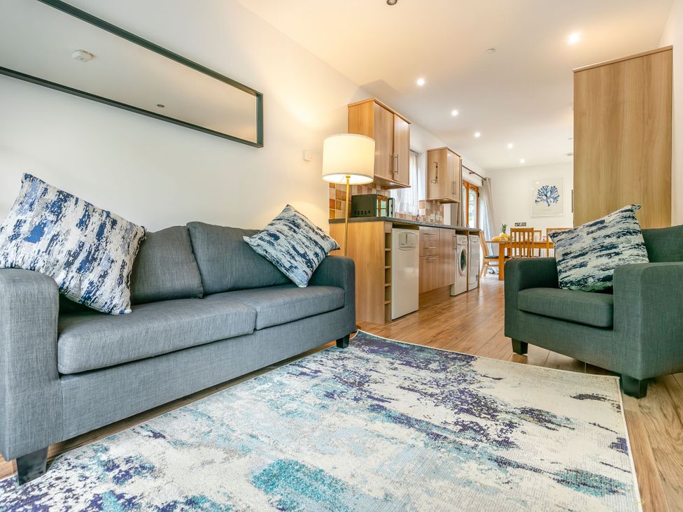A living room with a sofa and chairs at Treehouse Spa in Perranporth