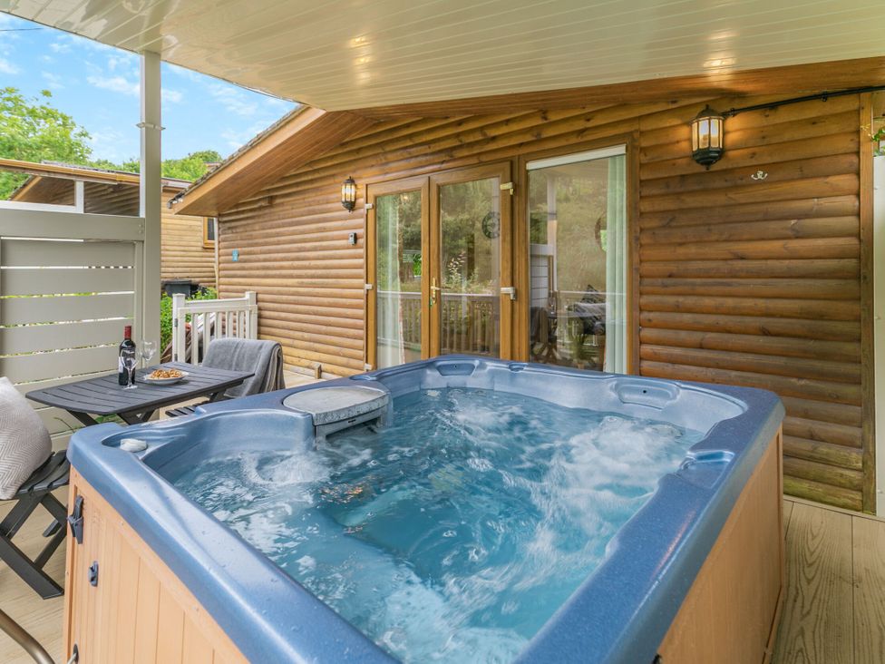 An outdoor patio with a hot tub and seating at Morva Spa Pet in Perranporth