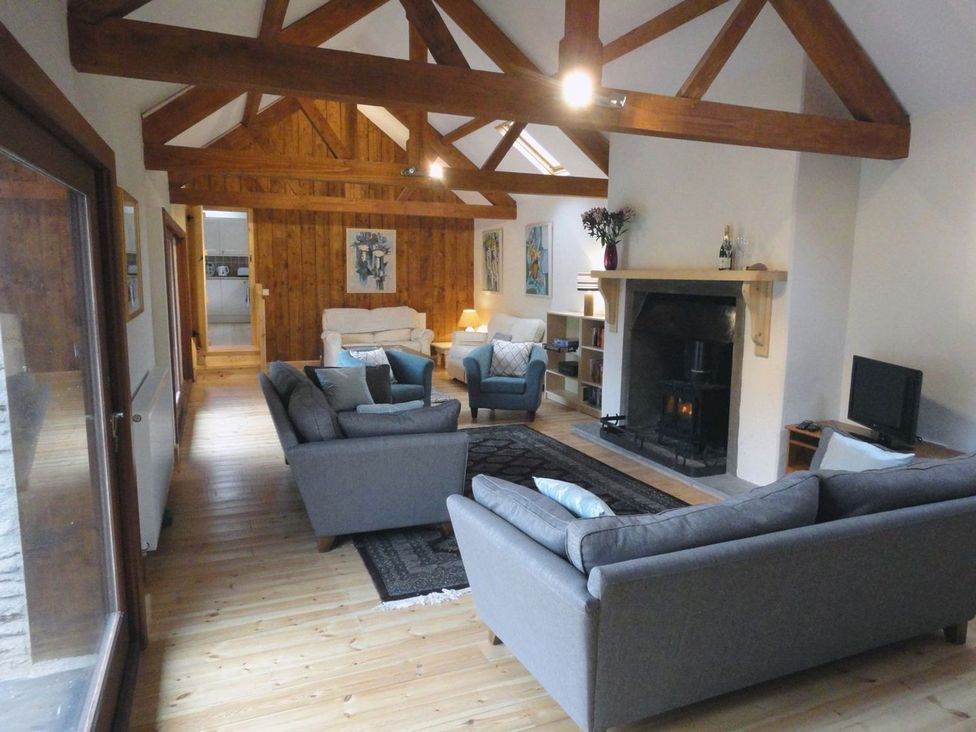 A living room with sofas and a fireplace at Nethercote Byre Minehead