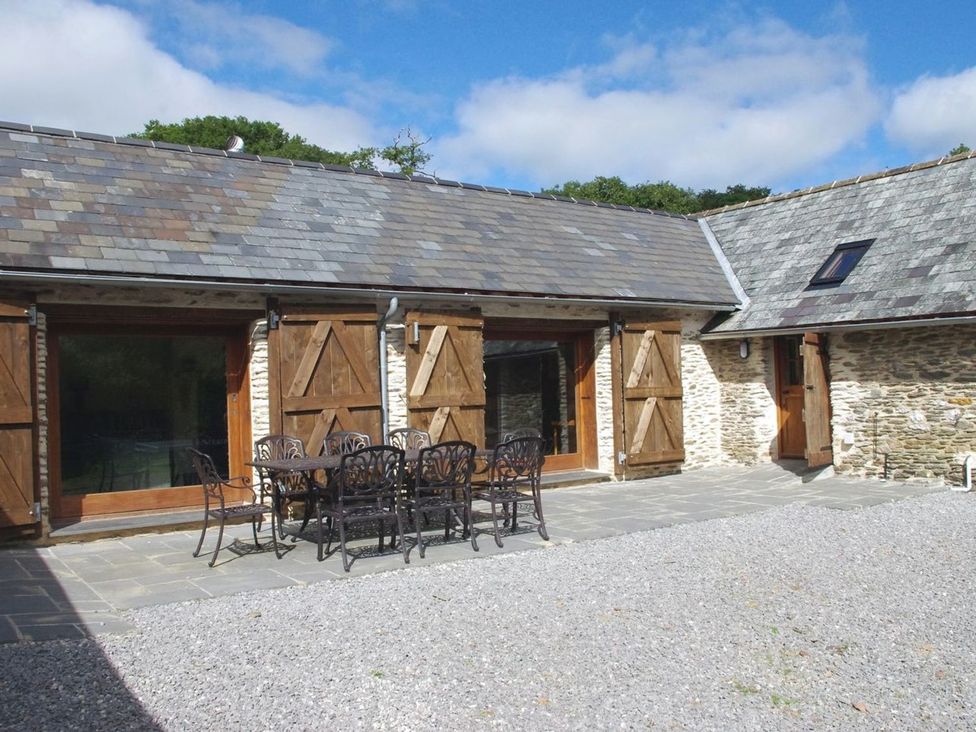 An outdoor seating area with a table and chairs at Nethercote Byre in Minehead