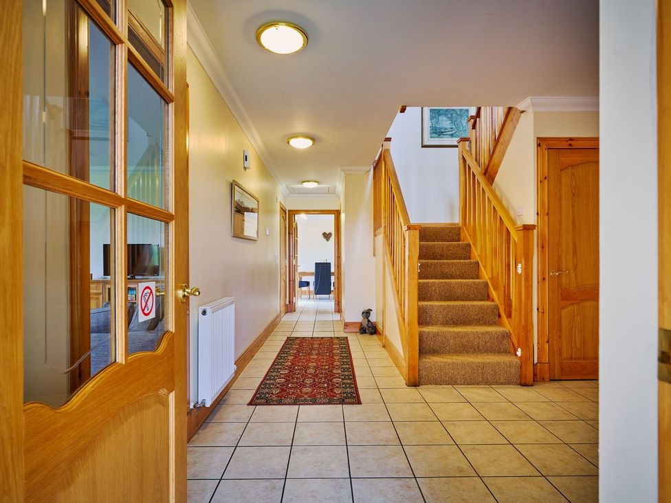A hallway with a staircase and door at Hazel Lodge Blairgowrie
