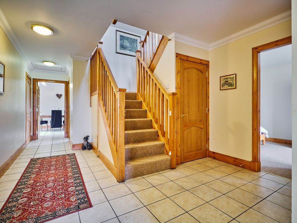 A hallway with stairs and a rug at Hazel Lodge in Blairgowrie