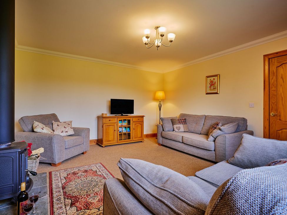 A living room with sofas and a television at Hazel Lodge in Blairgowrie