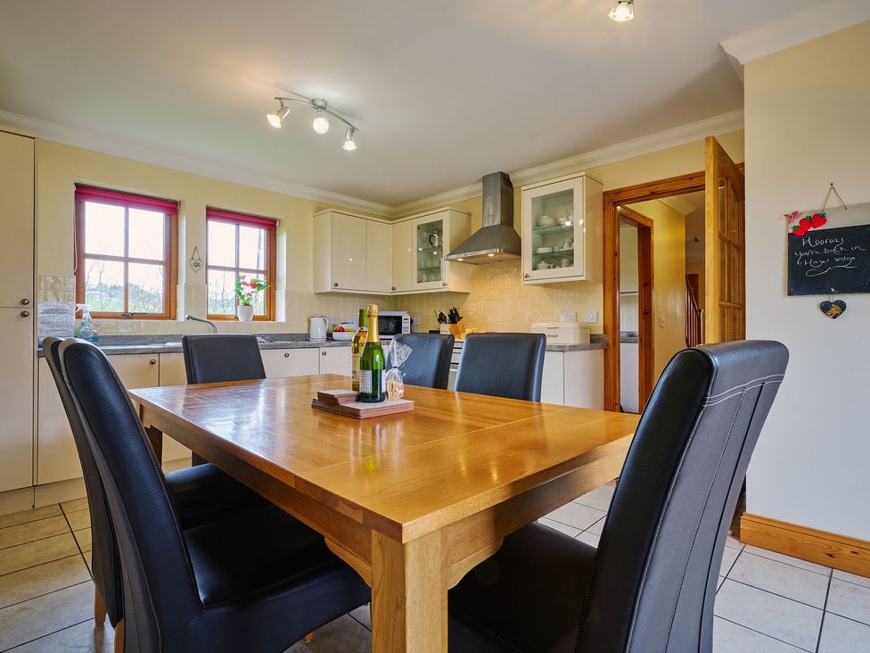 A kitchen with a dining table and chairs at Hazel Lodge in Blairgowrie