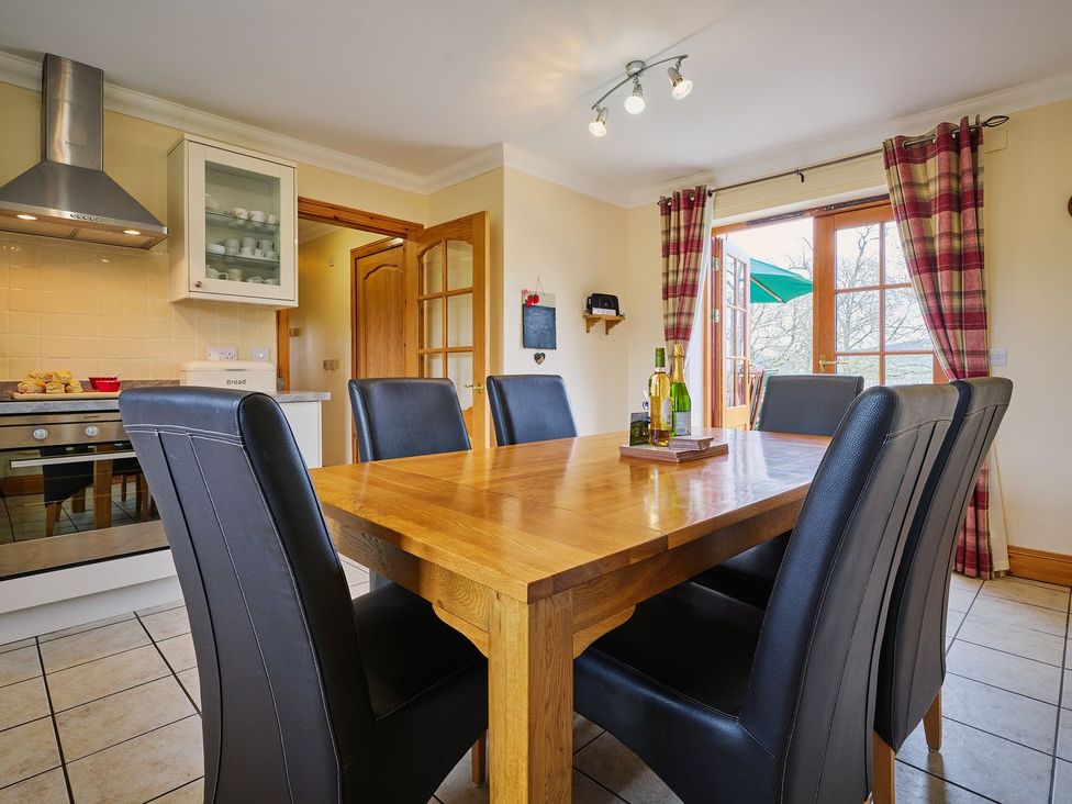 A kitchen with a dining table and chairs at Hazel Lodge in Blairgowrie