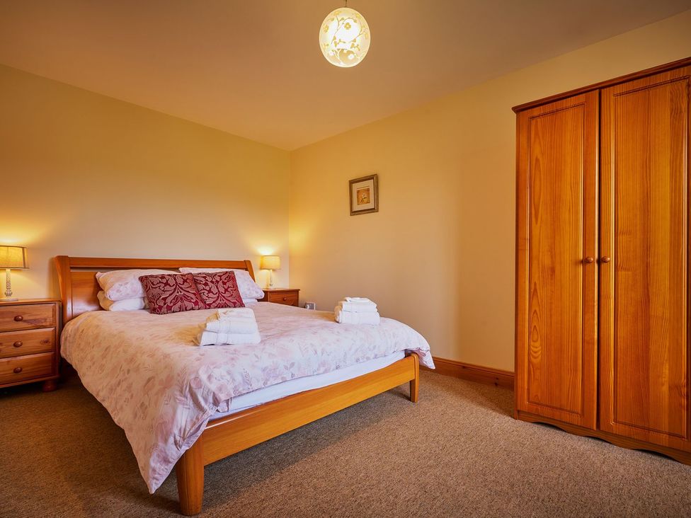 A bedroom with a bed and wardrobe at Hazel Lodge in Blairgowrie