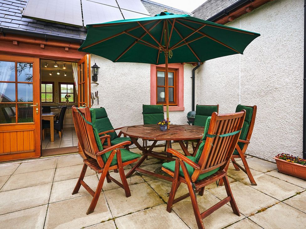 An outdoor seating area with a table and chairs at Hazel Lodge Blairgowrie