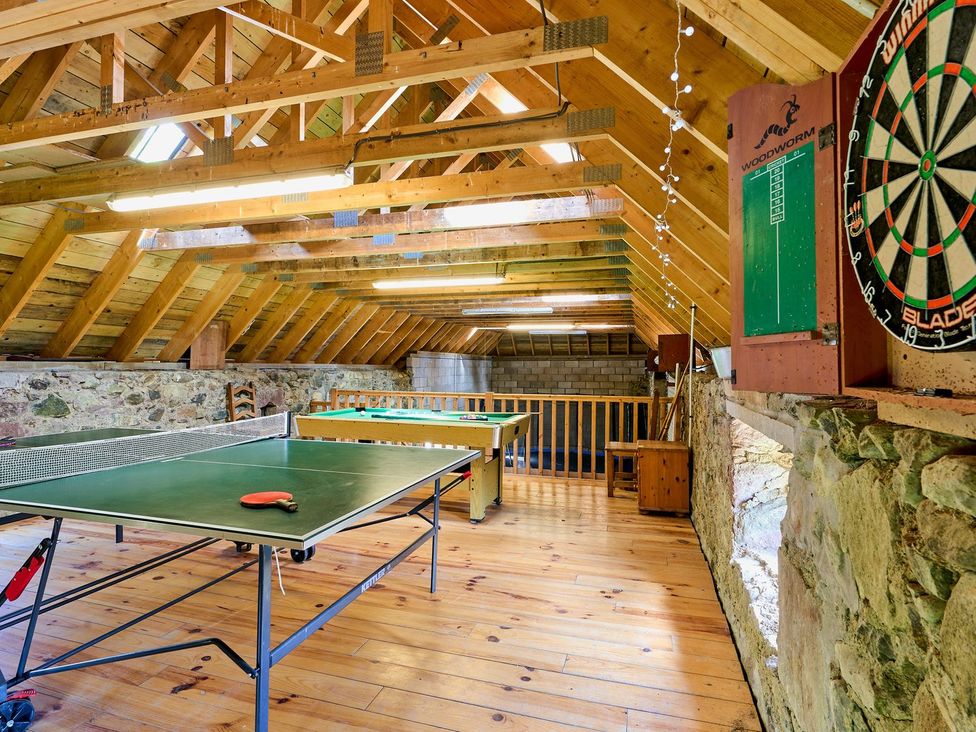 A game room with a table tennis table and dartboard at Hazel Lodge in Blairgowrie