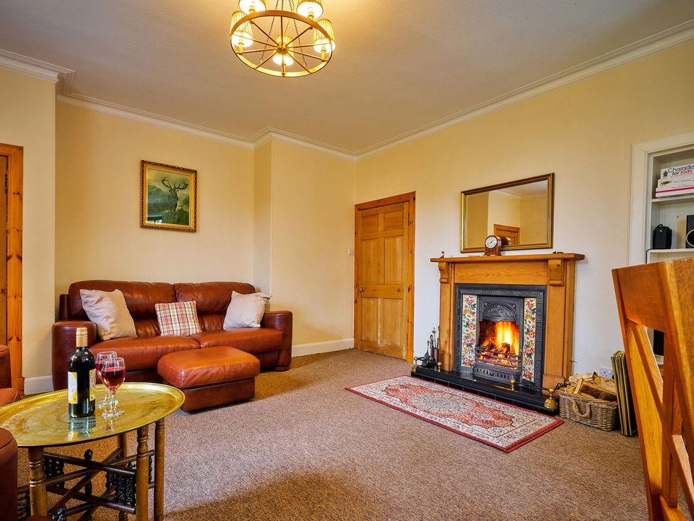 A living room with a sofa and fireplace at West Lodge Kirriemuir