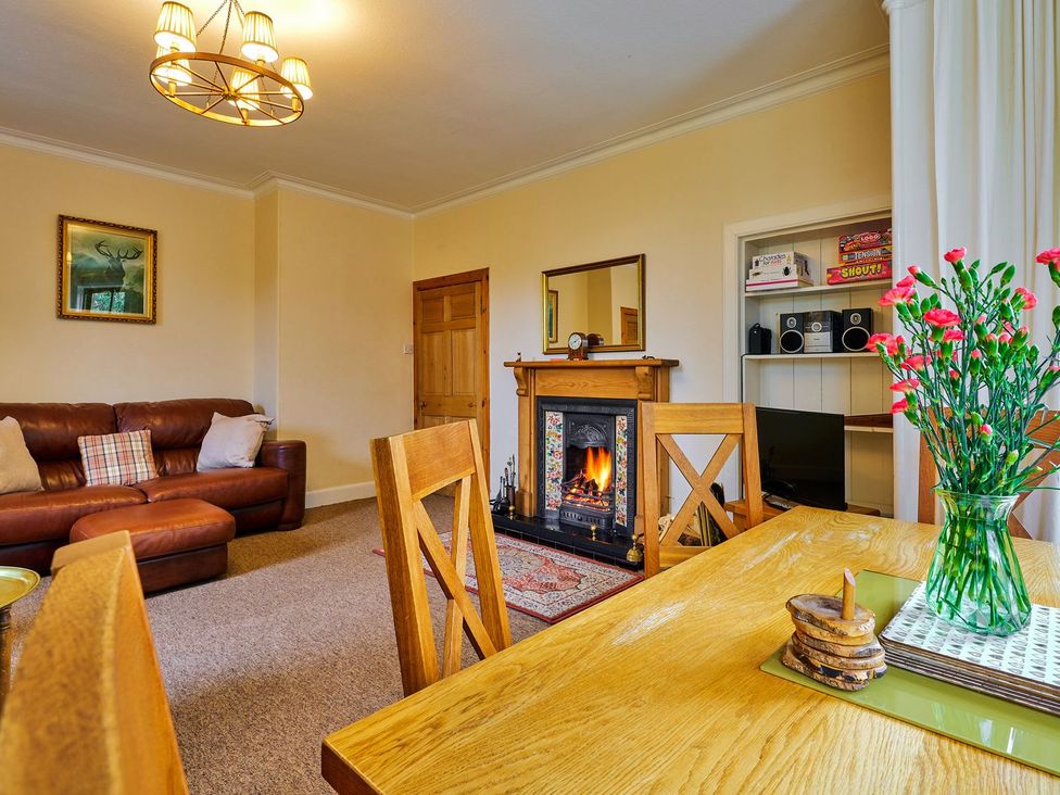 A living room with a fireplace and sofa at West Lodge in Kirriemuir