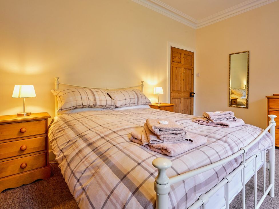 A bedroom with a bed and bedside lamps at West Lodge in Kirriemuir