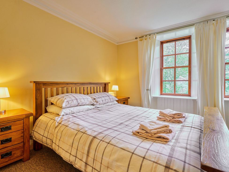 A bedroom with a bed and side tables at West Lodge Kirriemuir