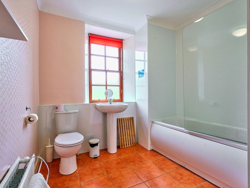 A bathroom with a bathtub, sink, and toilet at West Lodge in Kirriemuir
