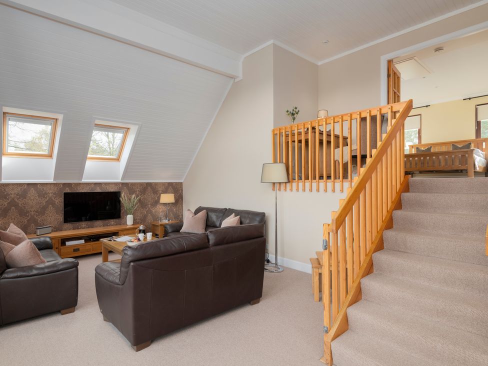A living room with seating area and staircase at The Derwent (Pet) in Slaley