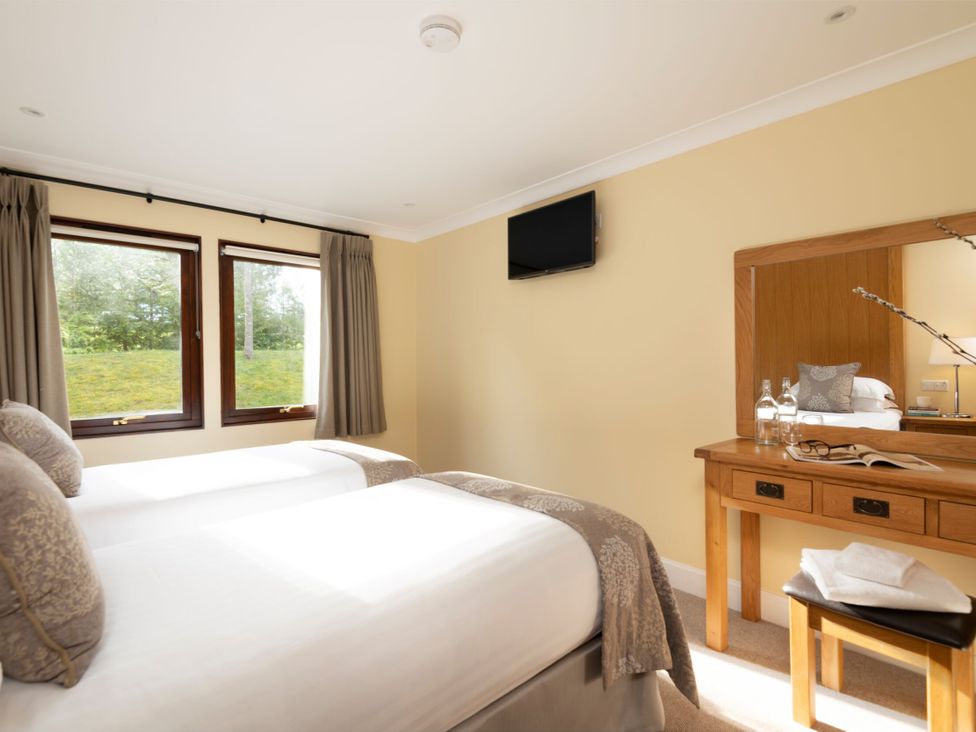 A bedroom with twin beds and a mirror at The Hexham in Slaley