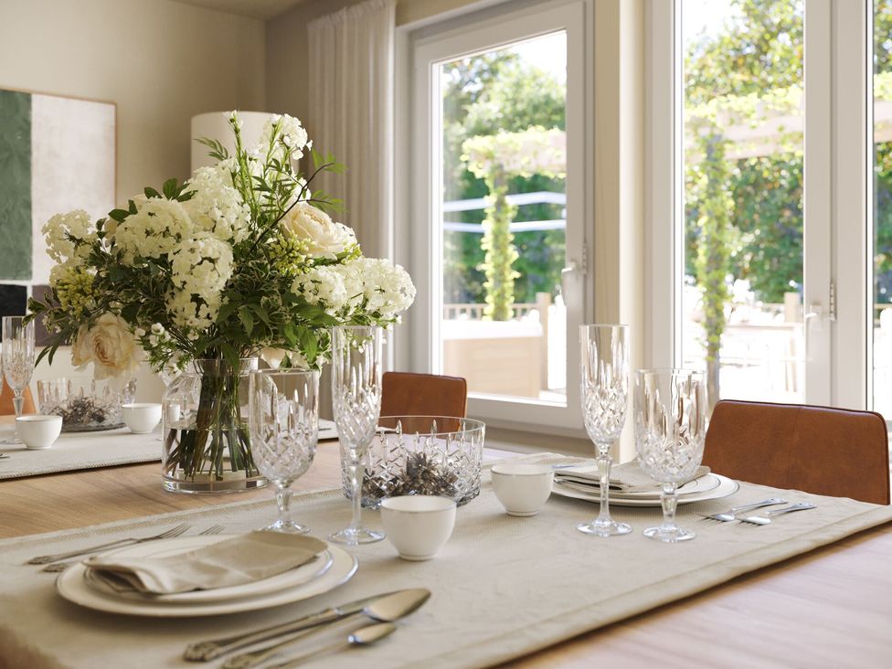 A dining room with a floral arrangement and tableware at Heatherwood (Pet) in Slaley