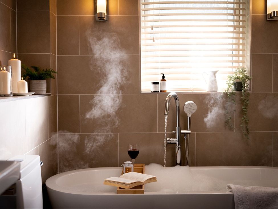 A bathroom with a bathtub and candles at The Hexham Spa in Slaley