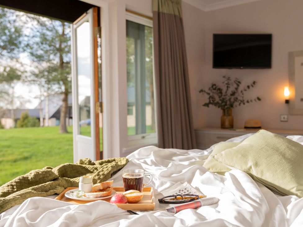 A bedroom with breakfast on a bed at The Hexham Spa in Slaley