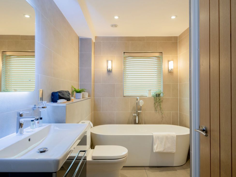 A bathroom with a bathtub, sink, and toilet at The Hexham Spa in Slaley
