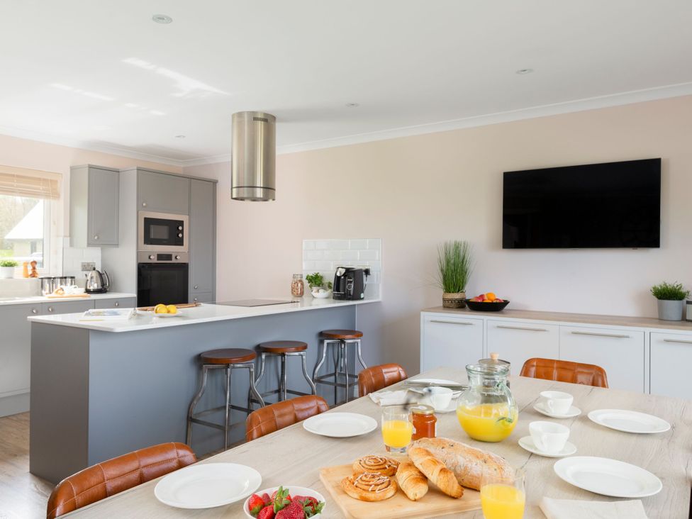 A kitchen with an island counter and dining table at The Hexham Spa in Slaley