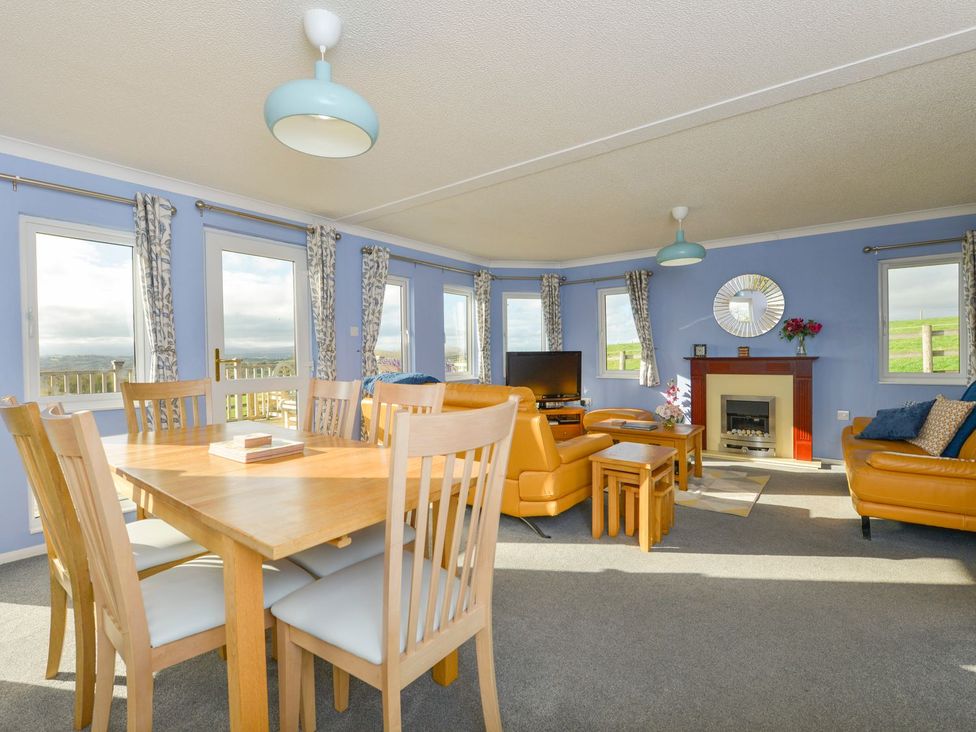 A living room with a dining area and television at Dartmoor View in Exeter