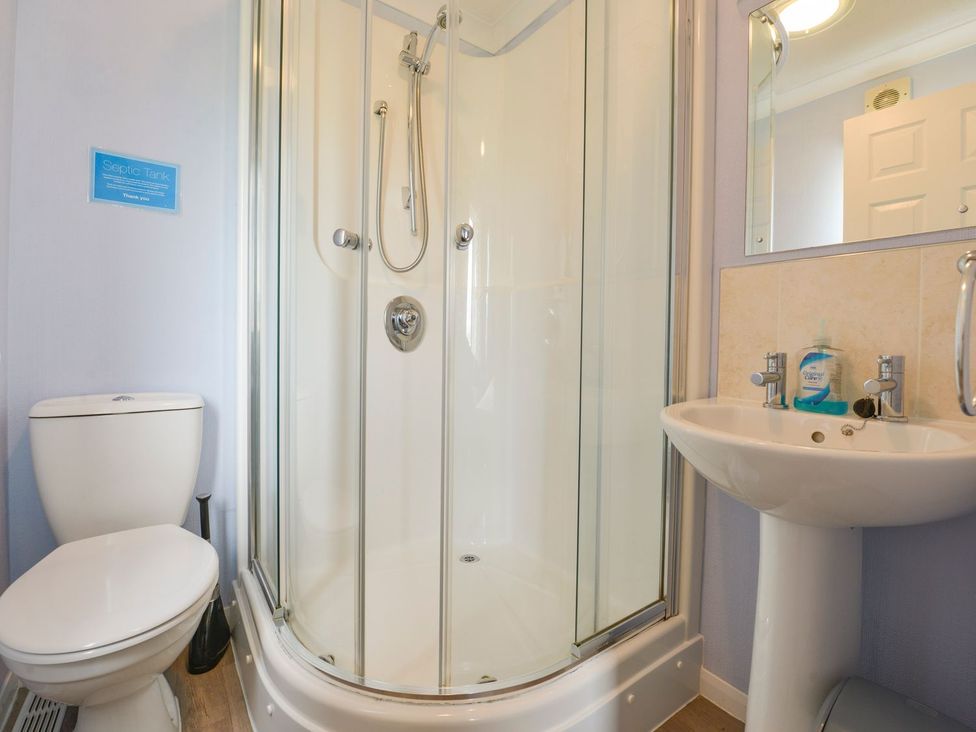 A bathroom with a shower, toilet, and sink at Dartmoor View in Exeter