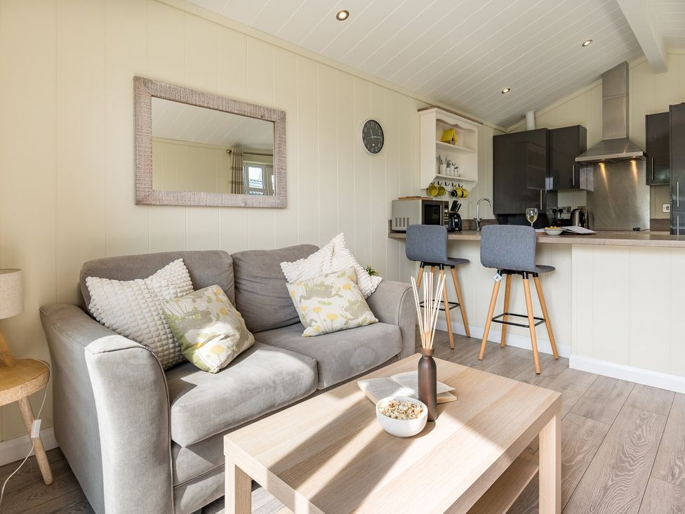 A living room with a sofa and kitchen counter at Stokesley (Pet) in Great Ayton