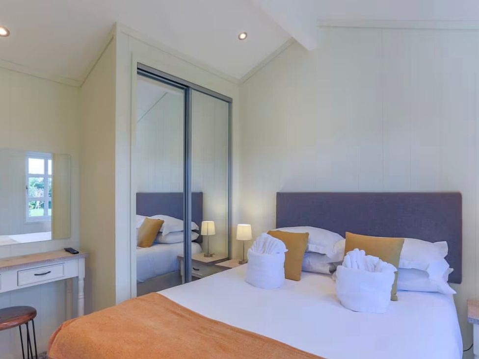 A bedroom with a bed and mirror at Stokesley (Pet) Great Ayton