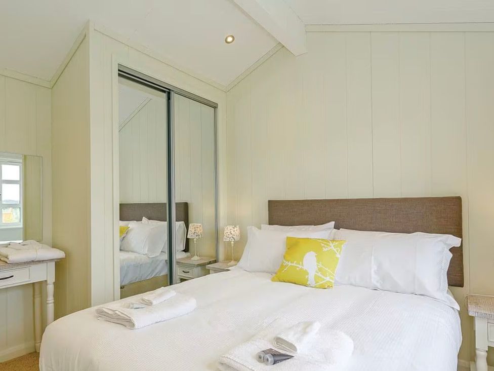 A bedroom with a bed and mirror at Stokesley (Pet) Great Ayton