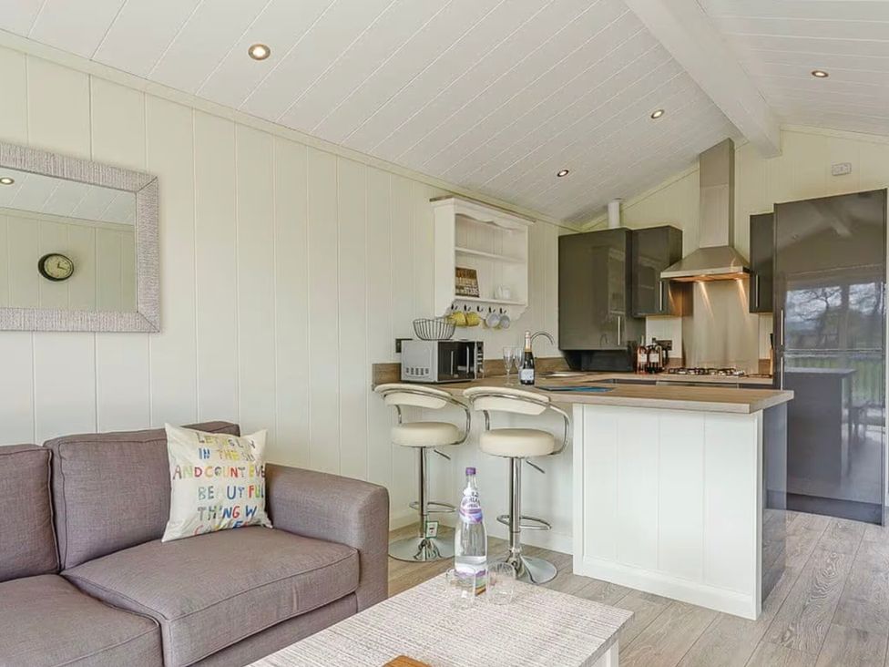 A kitchen with a sofa and bar stools at Stokesley (Pet) in Great Ayton