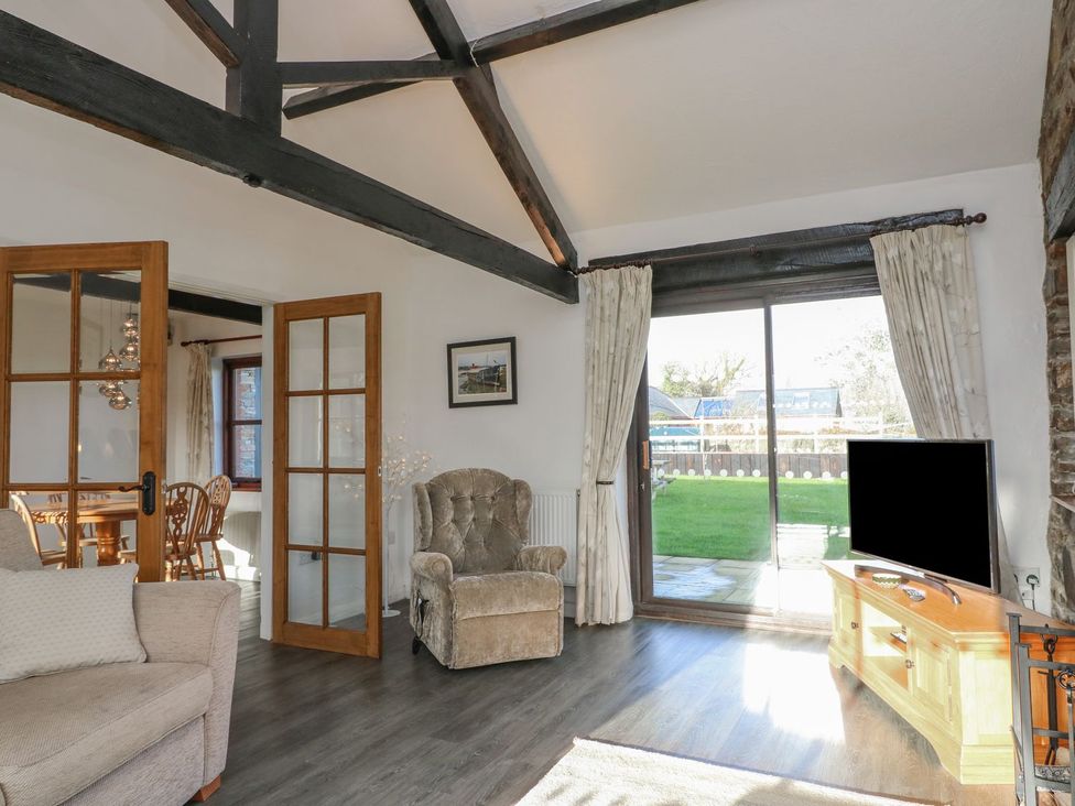 A living room with an armchair and sliding door at Long Linney in Bideford