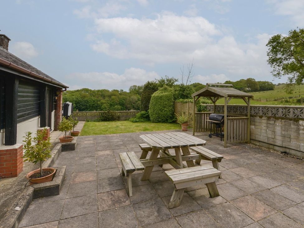 A garden with a picnic table and barbecue at Long Linney in Bideford