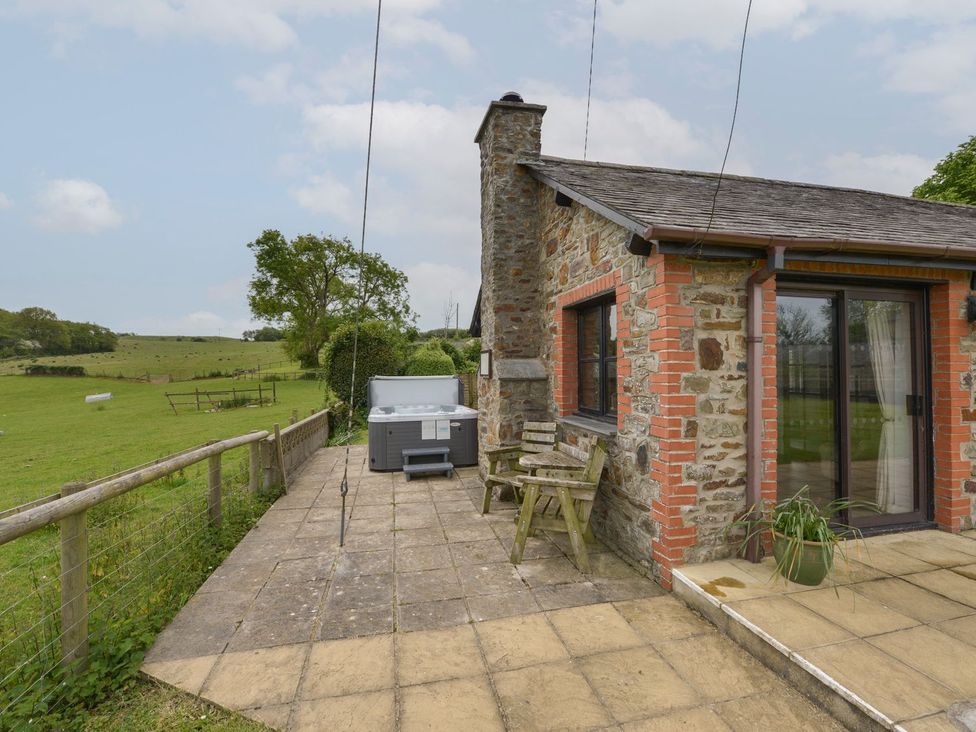 An outdoor area with a hot tub and seating at Long Linney in Bideford
