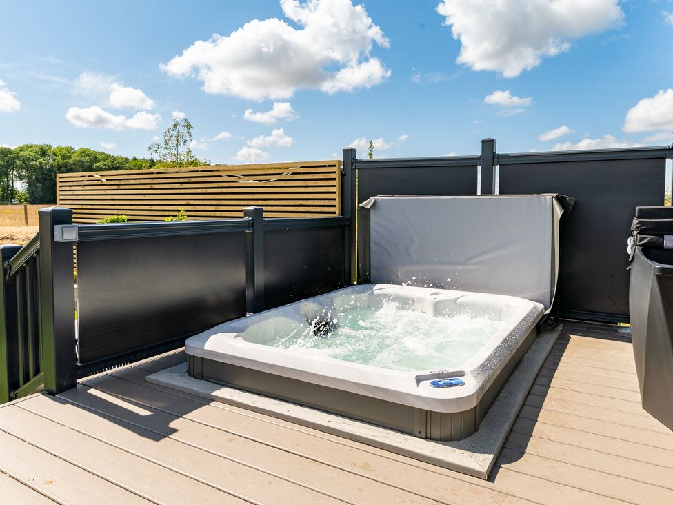 A hot tub on a wooden deck at The Oasis in Great Ayton